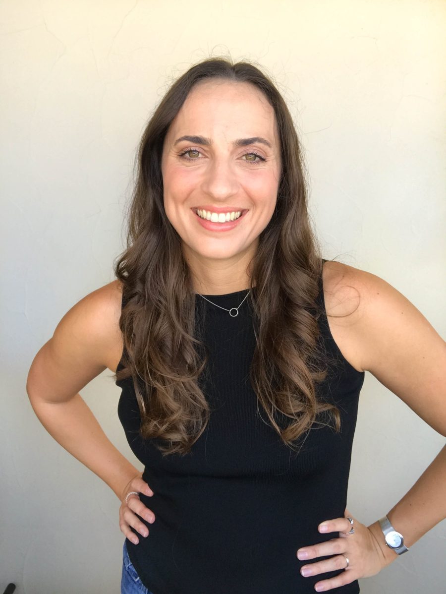 Nikki Dickerson smiling against a cream wall